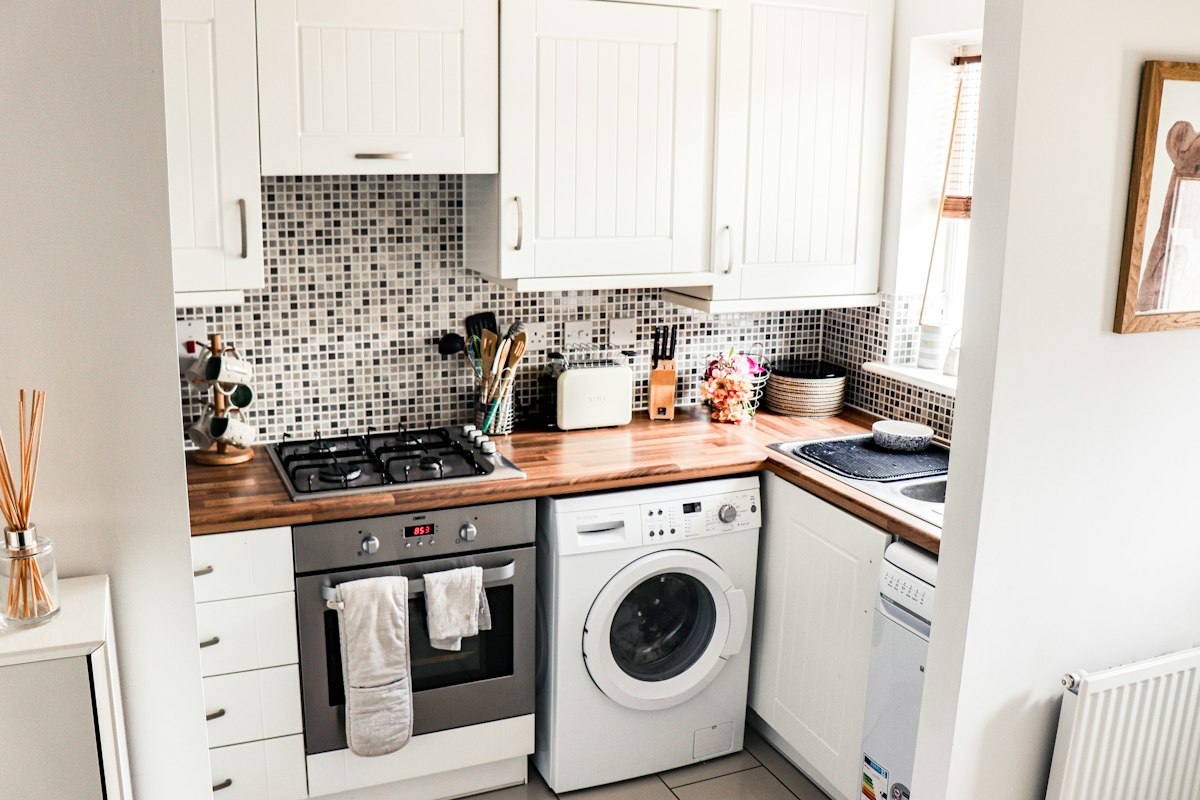 A small shared kitchen with a cooker and washing machine